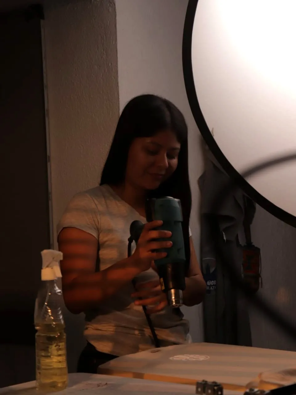 Integrante del taller secando un estampado con pistola de calor